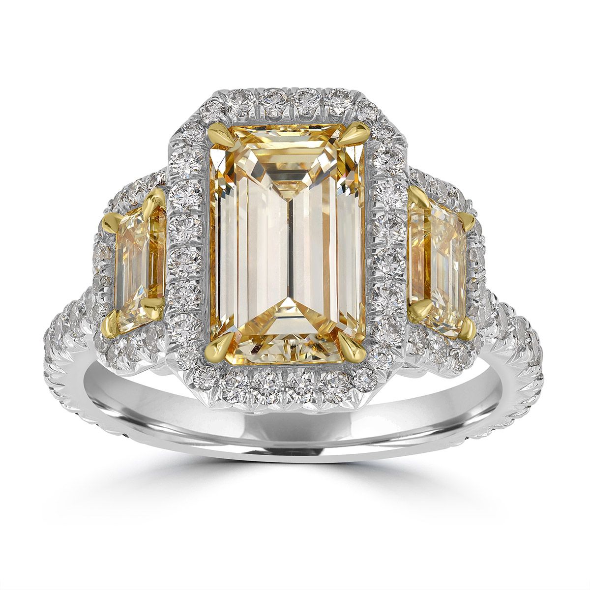 An emerald-cut yellow diamond three-stone ring retouched in NeuroViz — the metal and the background are cleaned, the stones are untouched.